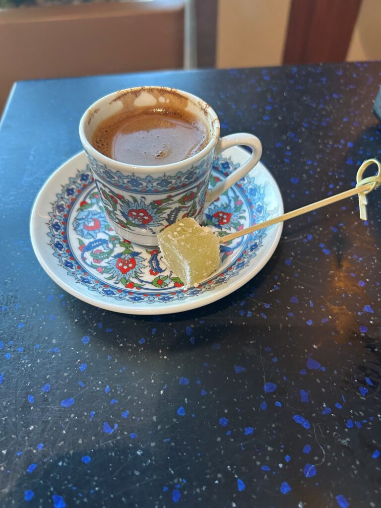 a cup of coffee and a piece of candy on a plate