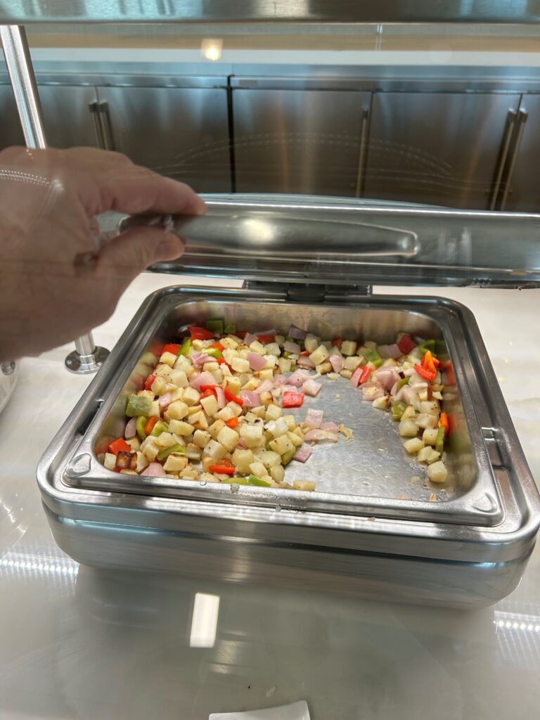 a hand holding a silver tray of food