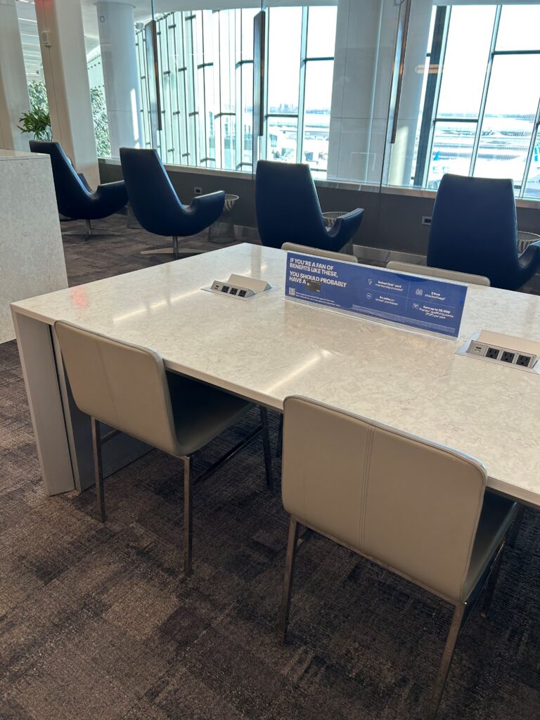 a white table with chairs in a room with windows