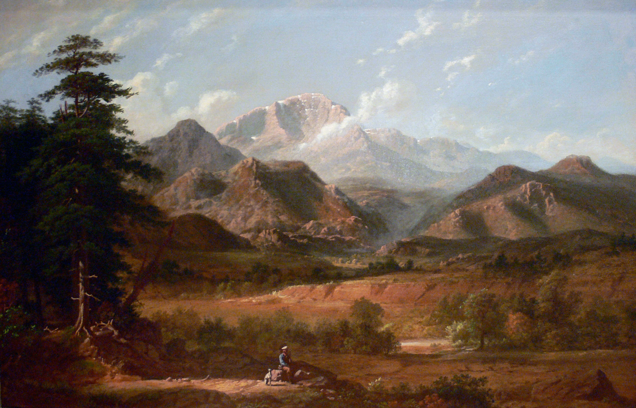 A landscape painting depicting a vast mountainous scene. In the foreground, a person on horseback is traveling along a dirt path. The middle ground features rolling hills with sparse vegetation, while the background showcases towering, rugged mountains under a partly cloudy sky. A large tree stands on the left side of the image, adding depth to the scene.