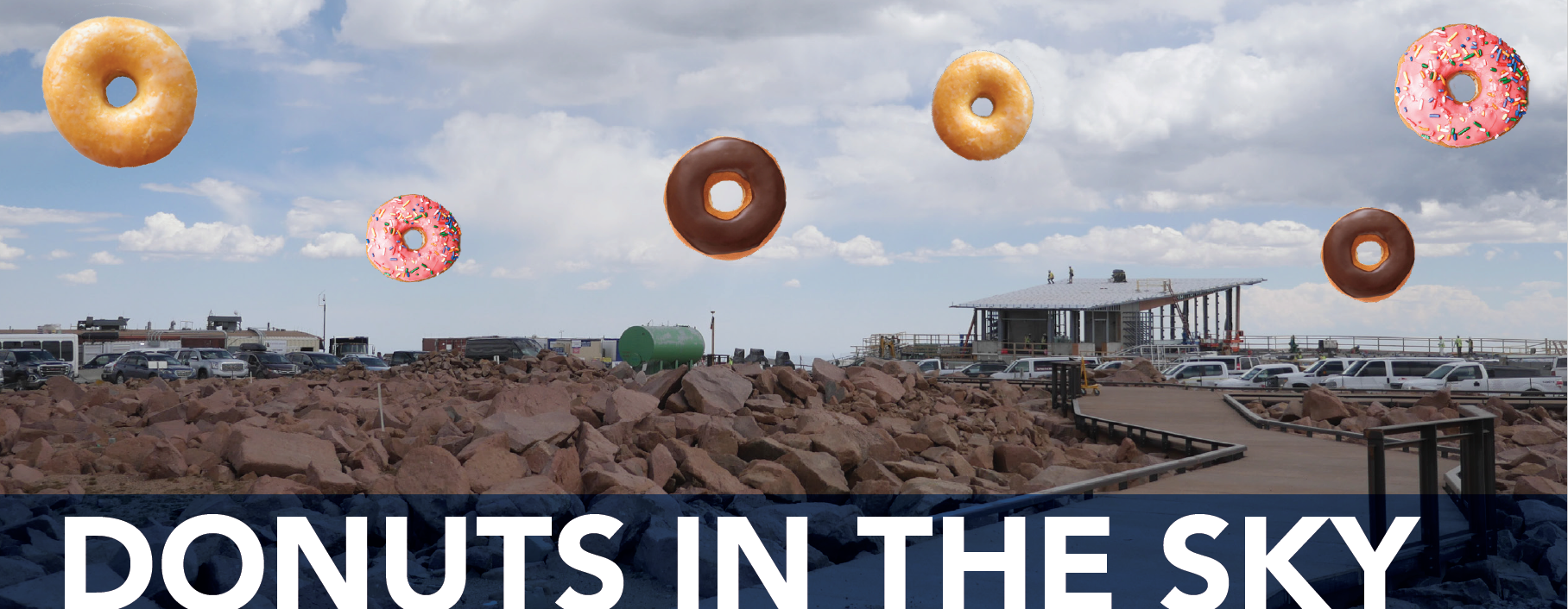 The image shows a rocky landscape with a parking area and a building in the background. In the sky, there are several large donuts floating, including glazed, chocolate, and pink frosted with sprinkles. At the bottom, there is text that reads "DONUTS IN THE SKY."