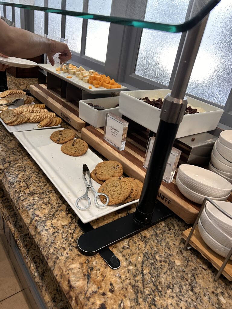 a person's hand reaching for food on a tray