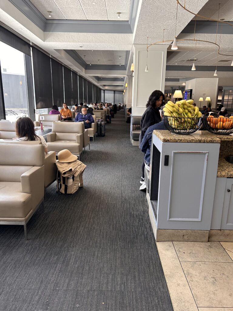a group of people sitting in a room with chairs and tables