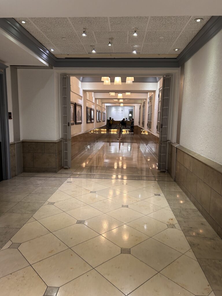 a hallway with a tile floor and a group of people