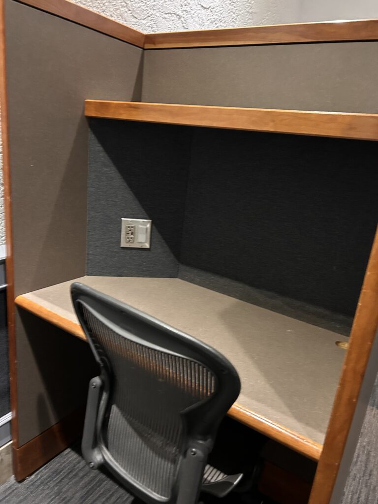 a chair in a corner with a wall and outlet