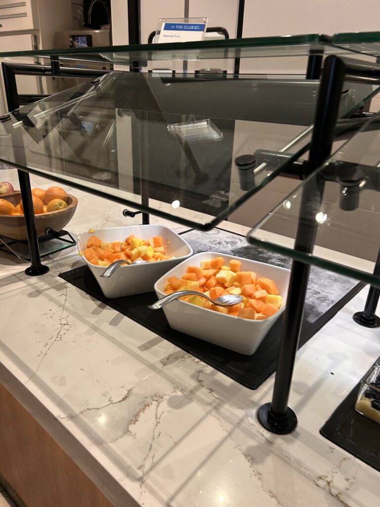 a group of bowls of fruit in a buffet