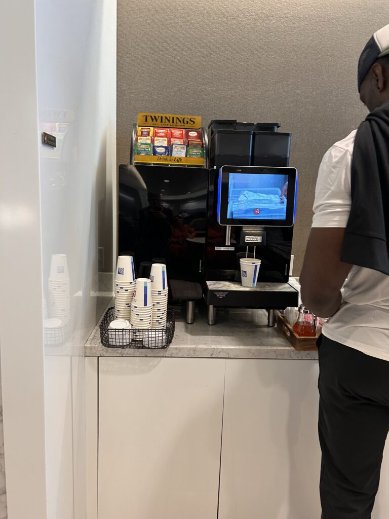a man standing next to a coffee machine