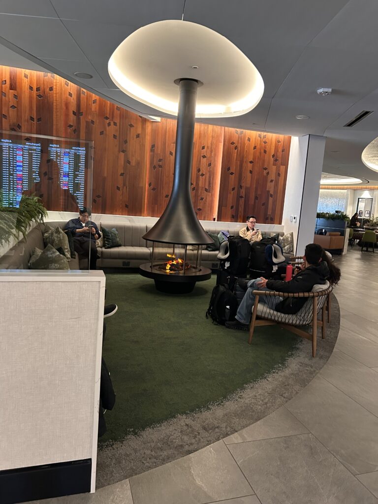 people sitting in a lounge area with a fire