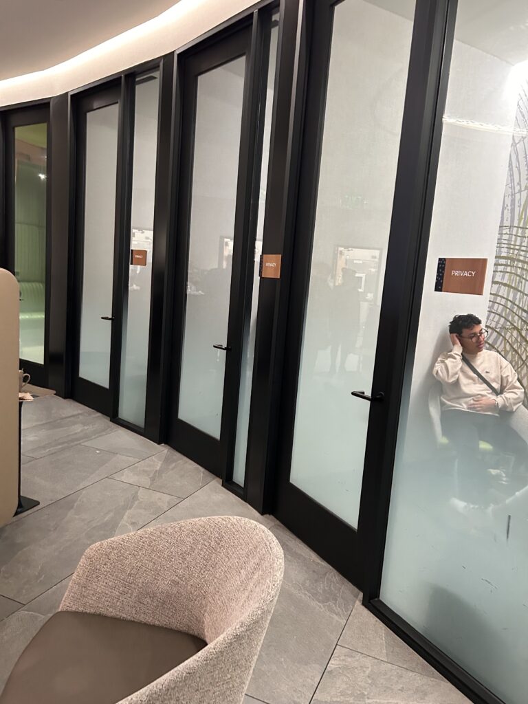 a man leaning against a wall with glass doors
