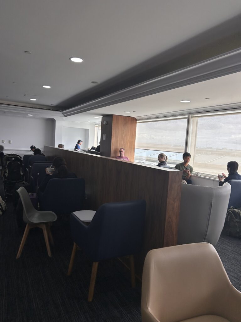 a group of people sitting in a room with a wall and chairs