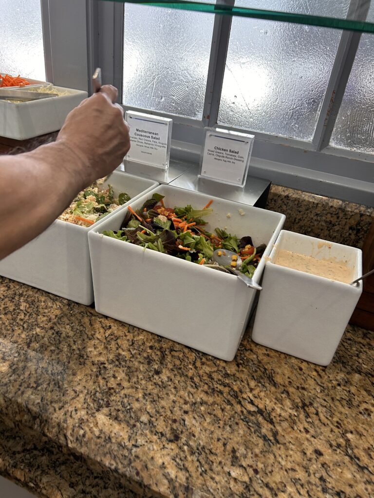a person holding a spoon in a salad bowl