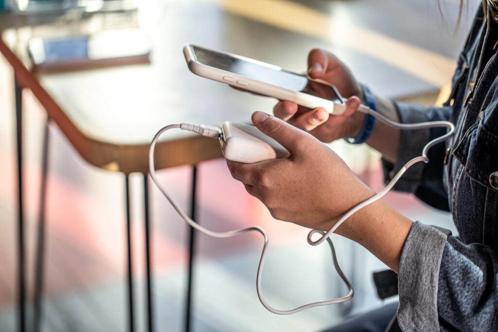 a person holding a phone and charging a charger