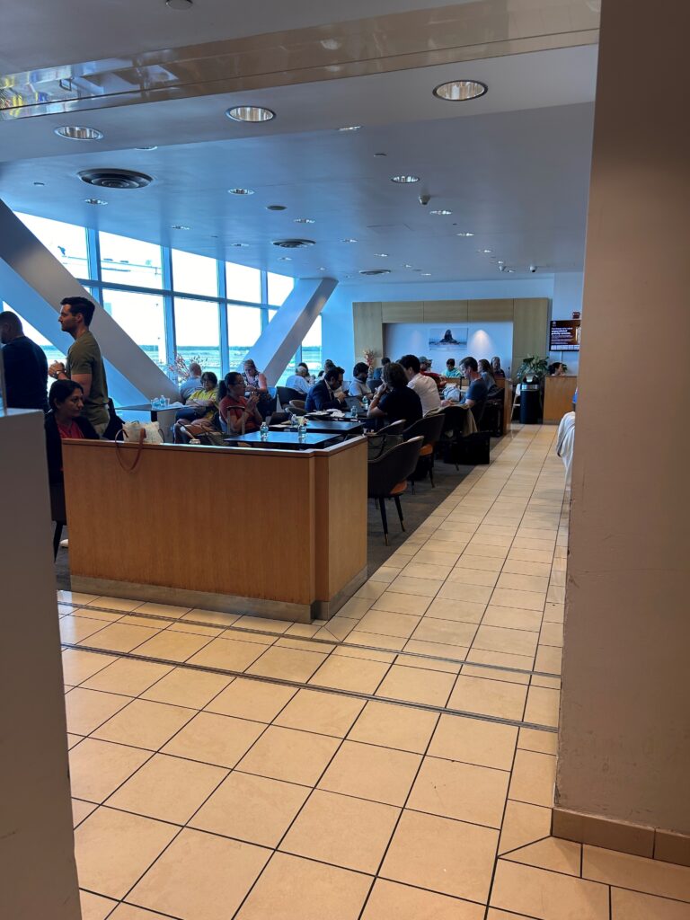 a group of people sitting at tables in a room with windows