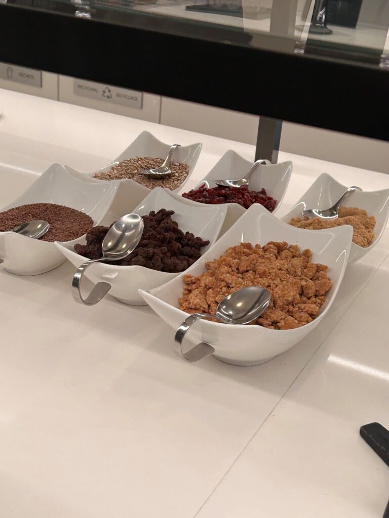 a row of bowls of cereal and spoons