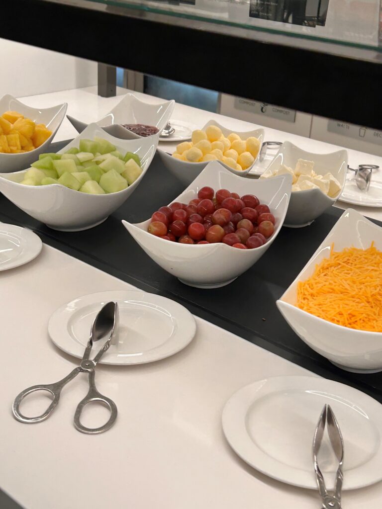a group of bowls of fruit and cheese on a table