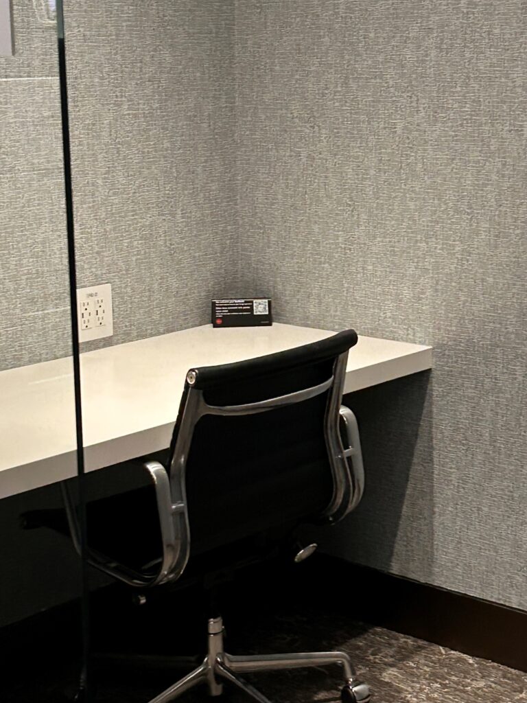 a desk with a chair and a mirror