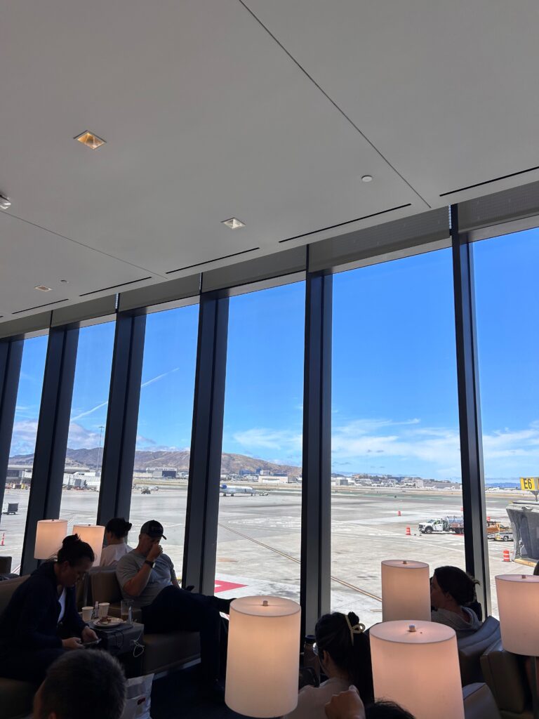 a group of people sitting at tables in a room with large windows