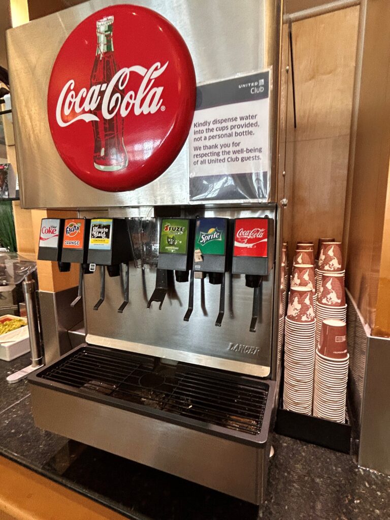 a soda dispenser machine with a red circle and a red circle with white text