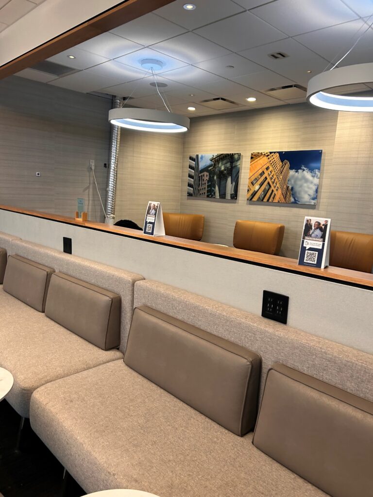 a reception desk with tan couches and a white table with a round white table with a white round table with a white round table with a white round table with a white round table with a white