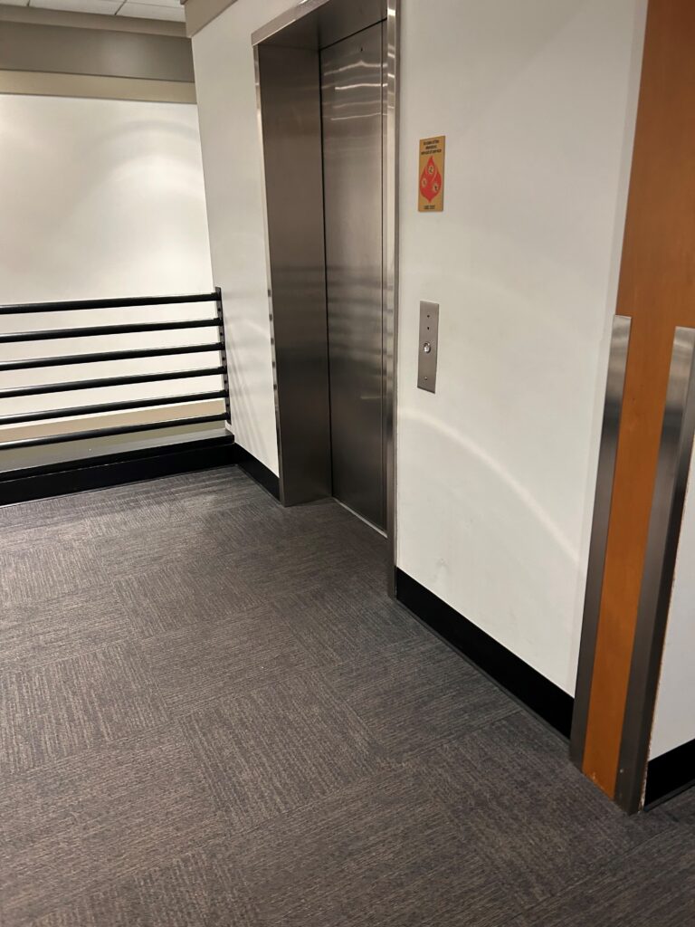 an elevator with a metal door and a metal railing