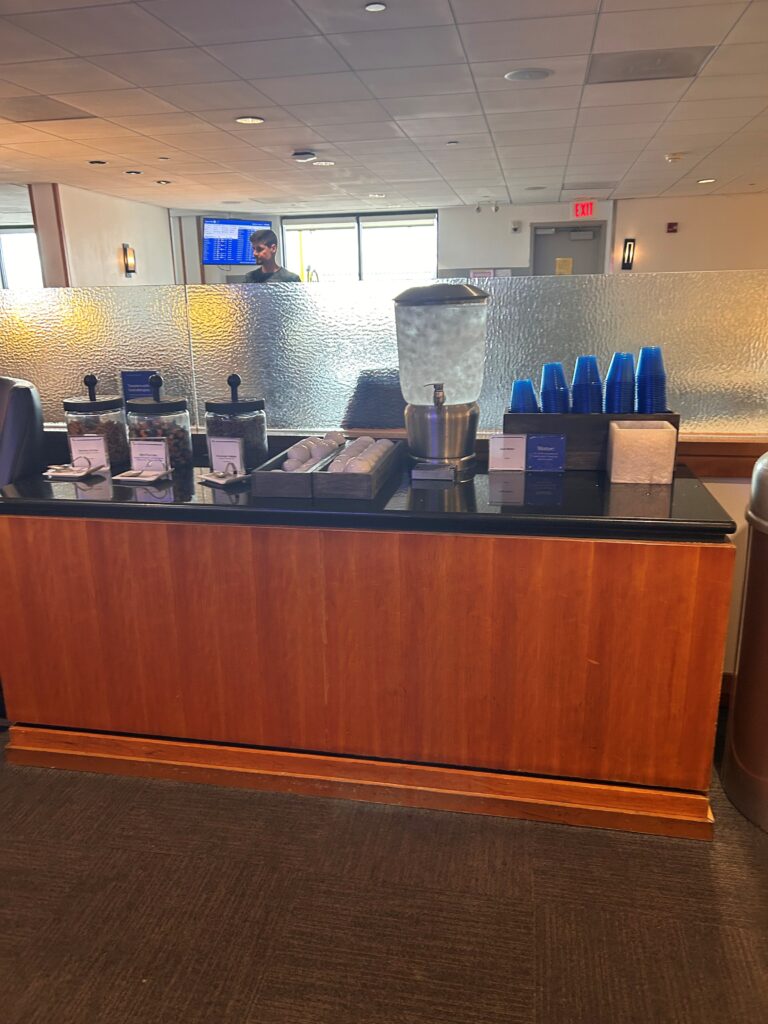 a counter with a drink dispenser and a glass container