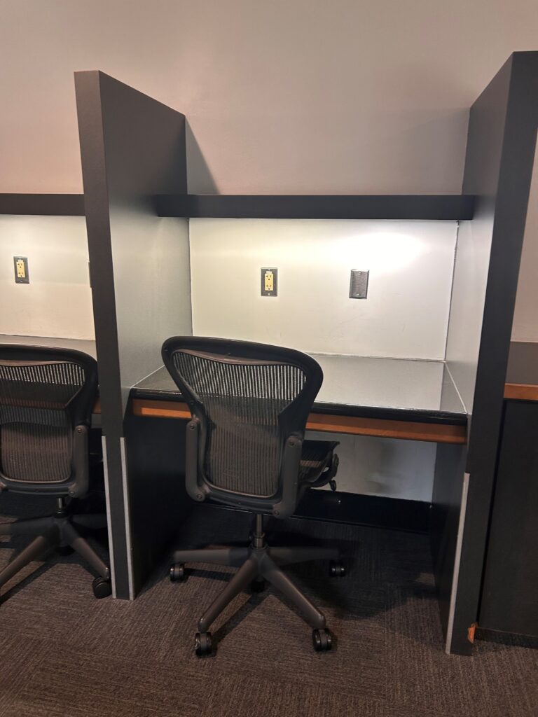 a desk with chairs and a wall