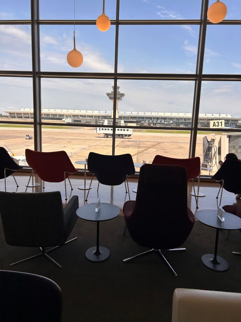 a group of chairs and tables in a room with a large window