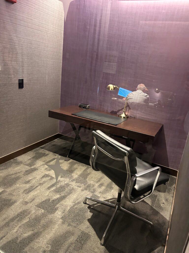 a desk with a lamp and a chair in a room