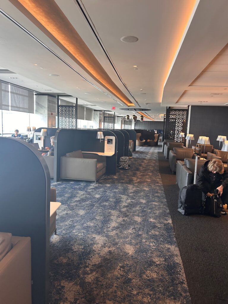 a person sitting on a luggage in a room with chairs and tables