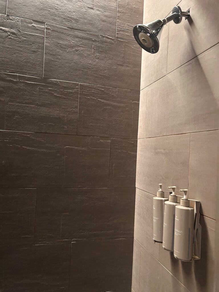 a shower head with soap dispensers on the wall