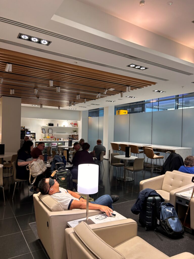 a group of people sitting in a room with chairs and tables