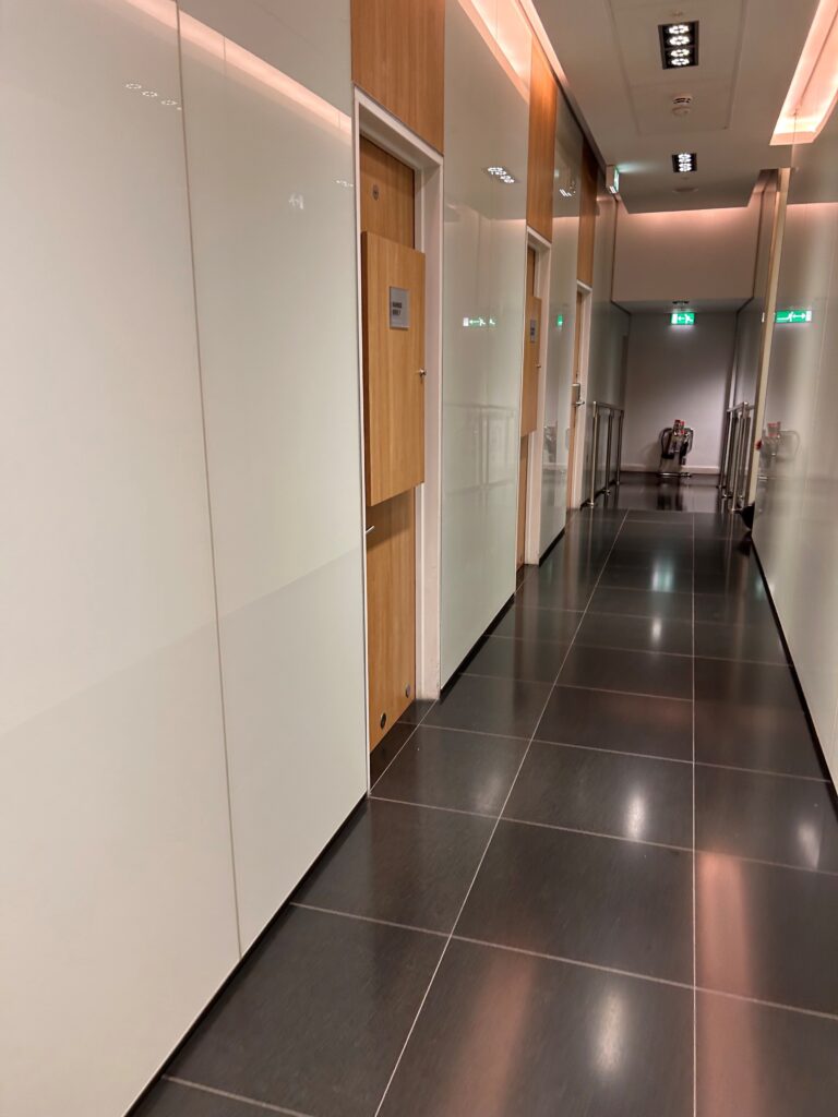 a hallway with white doors and black tile floor