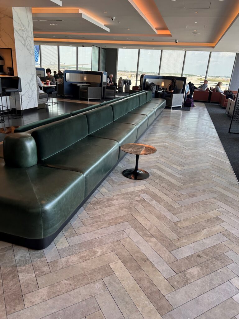 a large green couch in a room with people sitting around