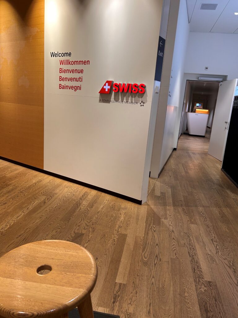 a wood floor with a round table in front of a white wall