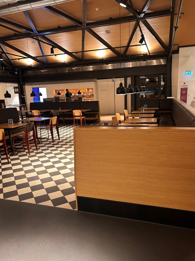 a room with a black and white checkered floor and a wood wall