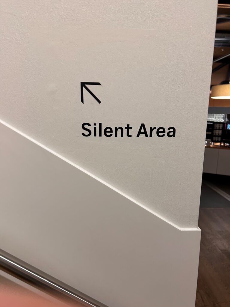 a white wall with black text and an arrow pointing to the left