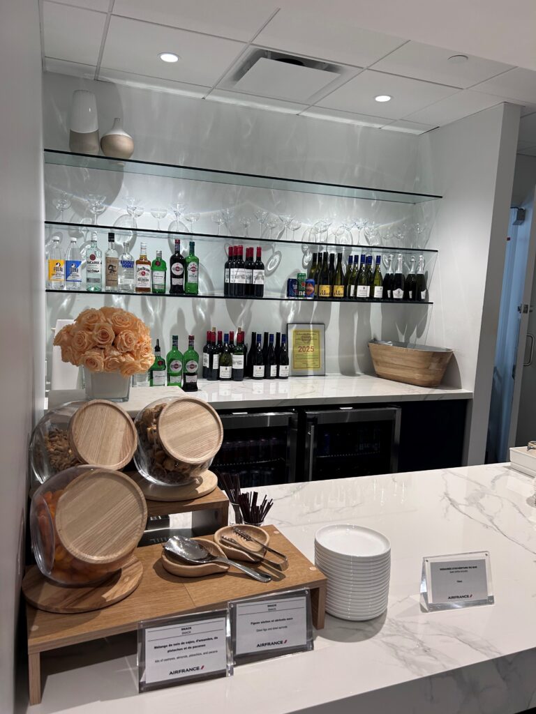 a bar with bottles of alcohol and a shelf with a vase of flowers