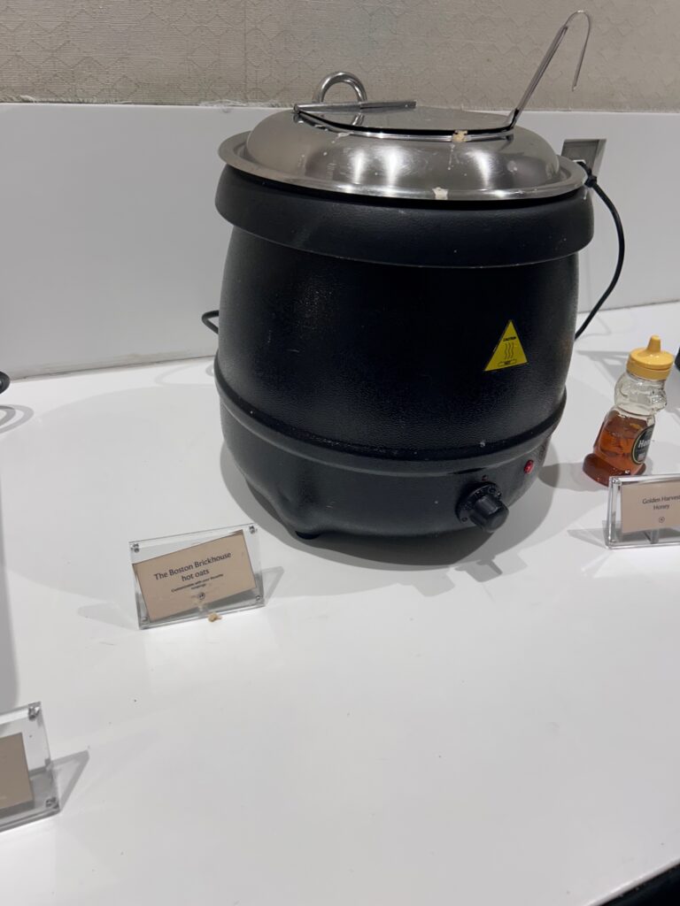 a black pot with a silver lid and a silver lid on a white surface