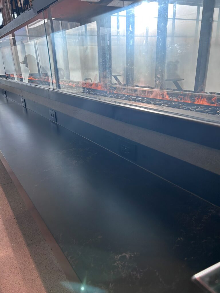 a glass wall with a conveyor belt with a person on fire