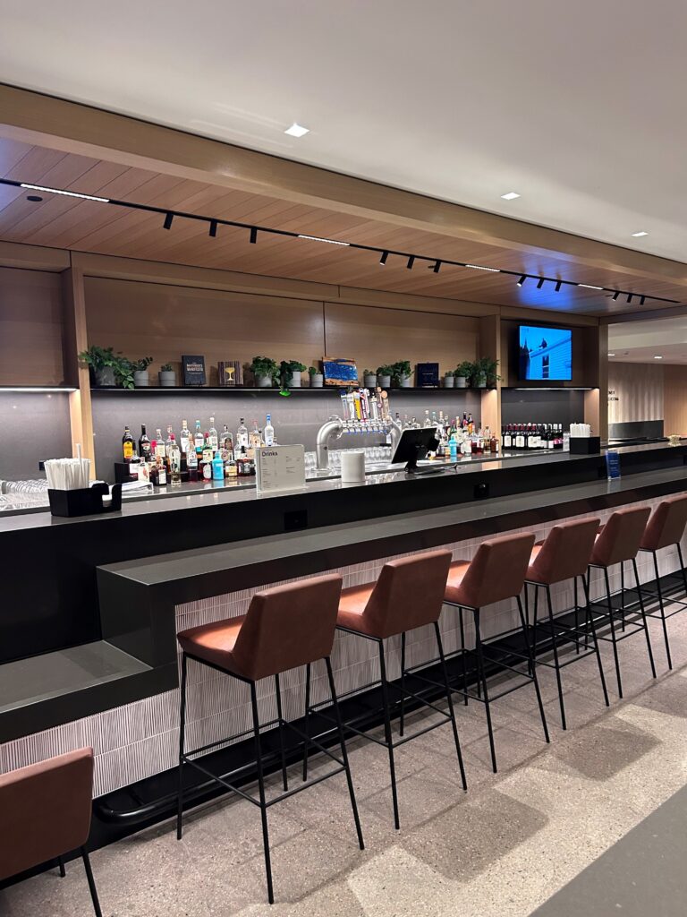 a bar with many bottles and chairs