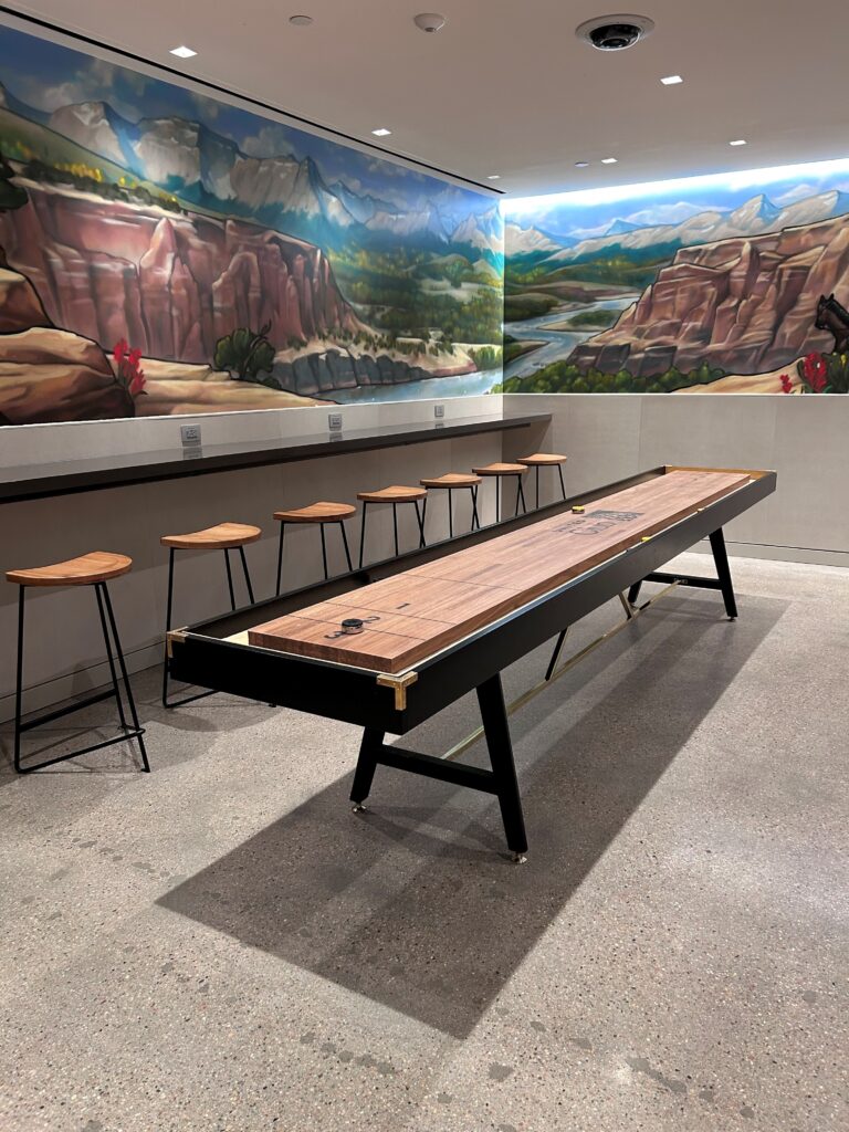 a table with stools in a room with a mural on the wall