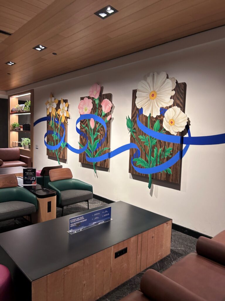 a wall with flowers and blue ribbon on it