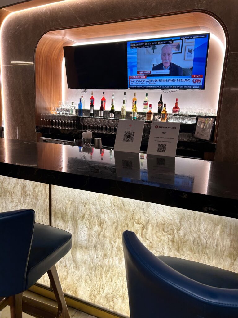 a bar with a row of bottles and a television