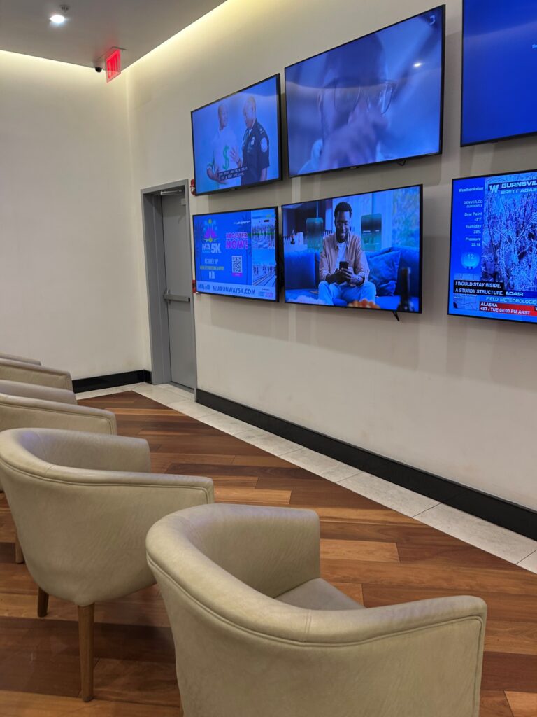 a room with several screens on the wall