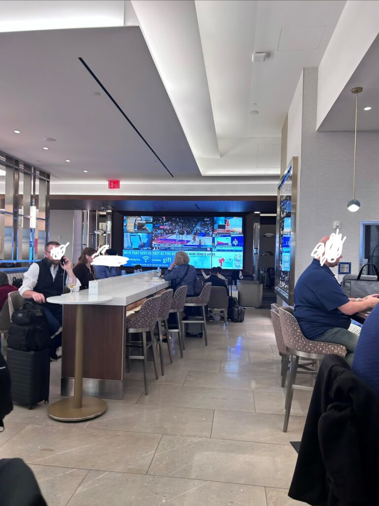 people sitting at a table with a large screen