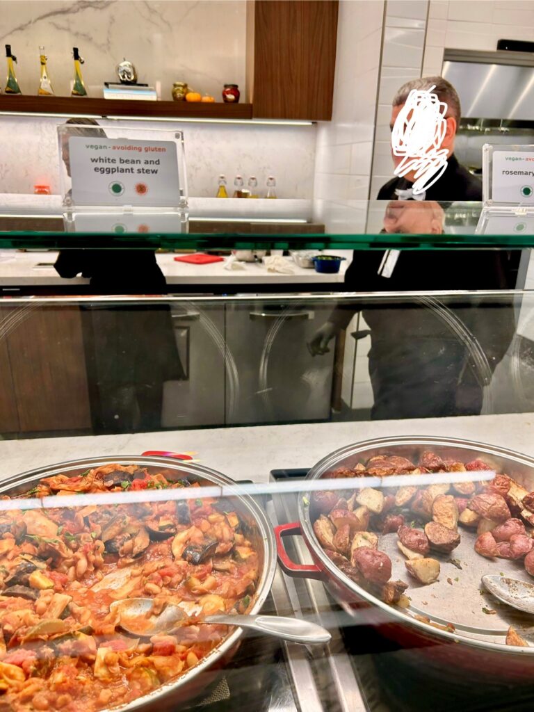a man standing behind a glass case with food in it
