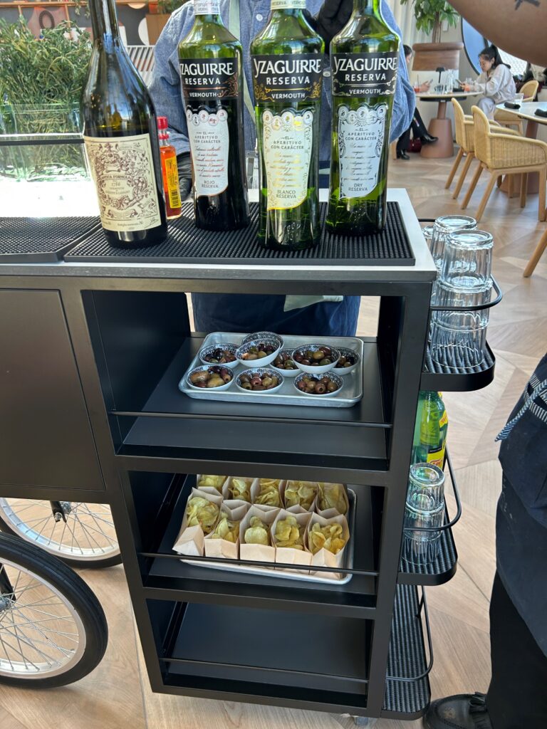 a cart with bottles of wine and snacks on it