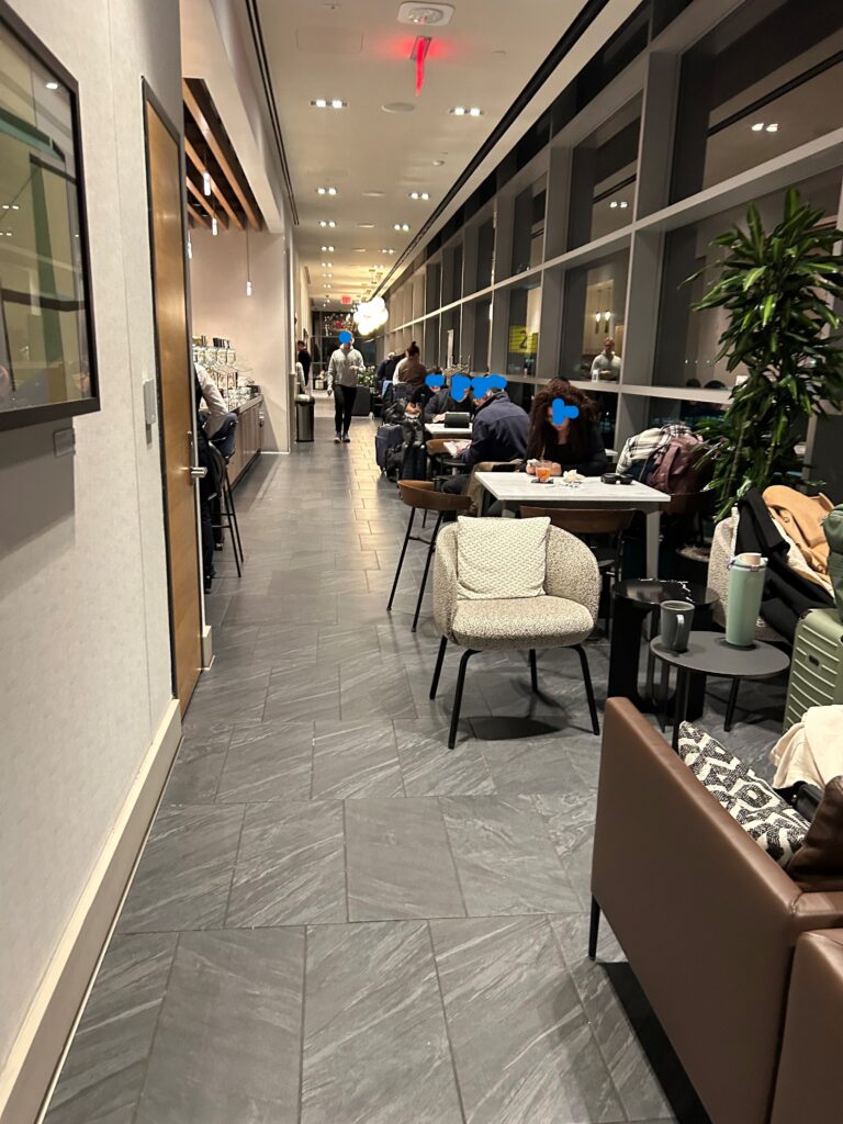 a long hallway with people sitting at tables and chairs