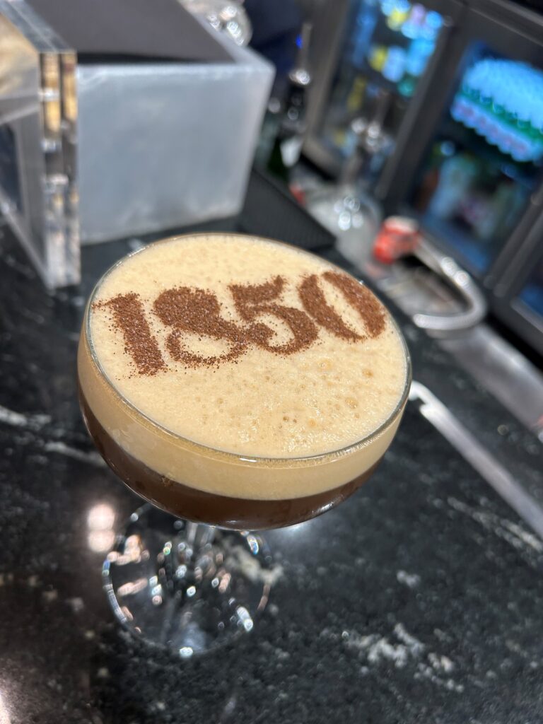 a drink with brown liquid and text on top