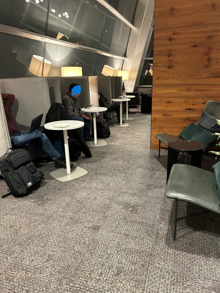 people sitting in a room with chairs and tables